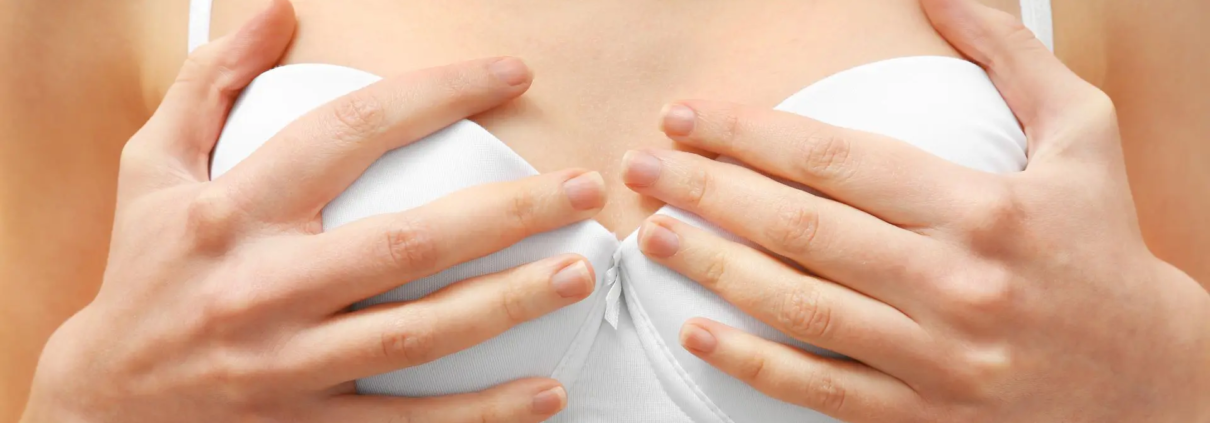 Abbildung einer Frau, die einen BH trägt und mit ihren Händen ihre Brüste umfasst.